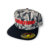 A stylish and trendy black baseball cap with a flat bill and an adjustable snap back. The front of the cap features a vibrant Red color embroidery with the word "Azhiaziam". The visor and back of the cap showcase a unique Birds of Paradise print.